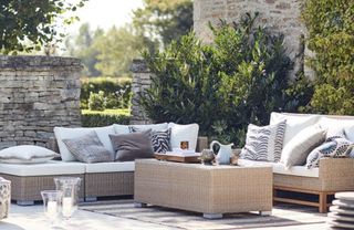 A rattan garden furniture set in a formal garden