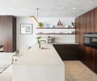 A white kitchen worktop connected as one long kitchen unit from a wooden kitchen wall