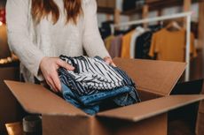 A woman is preparing the shipment of some clothes in her online shop.