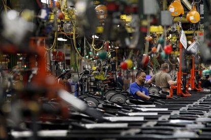 Workers perform assembly on SUV chassis at the General Motors Assembly Plant in Arlington, Texas.