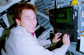 STS-67 payload specialist Samuel Durrance works with the Astro-2 data display system set up on space shuttle Endeavour's flight deck in March 1995.