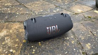 JBL Xtreme 4 wireless speaker on rainy pavement