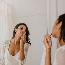 Best lipstick for a wedding - woman applying lipstick on her wedding day