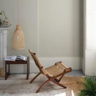 A warm neutral wall with a chair facing a window