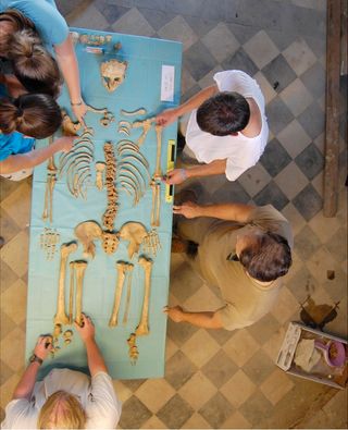Undergraduate students study the bones of a young man excavated from the Badia Pozzeveri cemetery in Tuscany, Italy. The area was used as a graveyard for nearly 1,000 years, including during a global cholera epidemic in the 1850s.