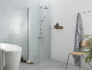 Pale blue shower room tiles in wetroom with bath
