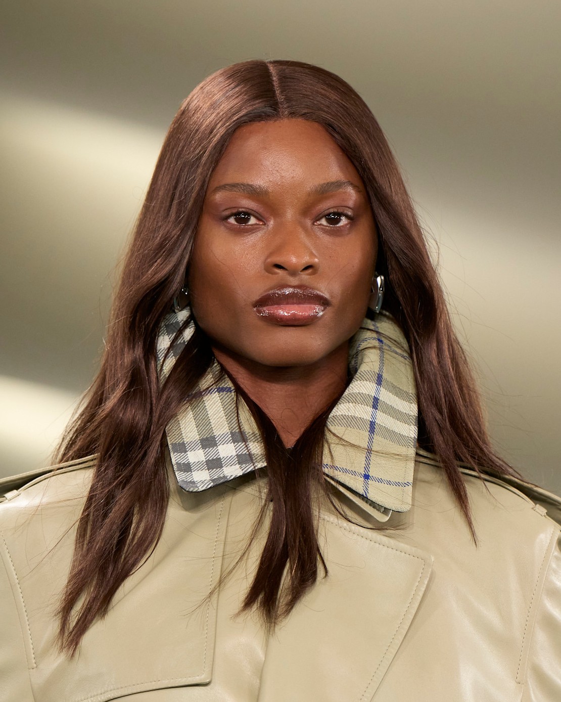 A model with red hair in a khaki jacket with plaid lapels