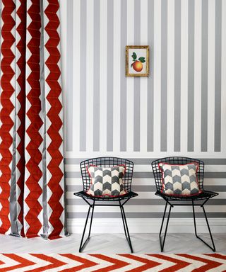 Side chairs with geometric patterned pillows, curtain with geometric strips and chevron rug