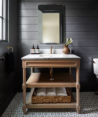 Bathroom with black shiplap paneling and wooden vanity