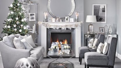  Silver chrome festive living room, Christmas tree in small space behind sofa, lit fire.