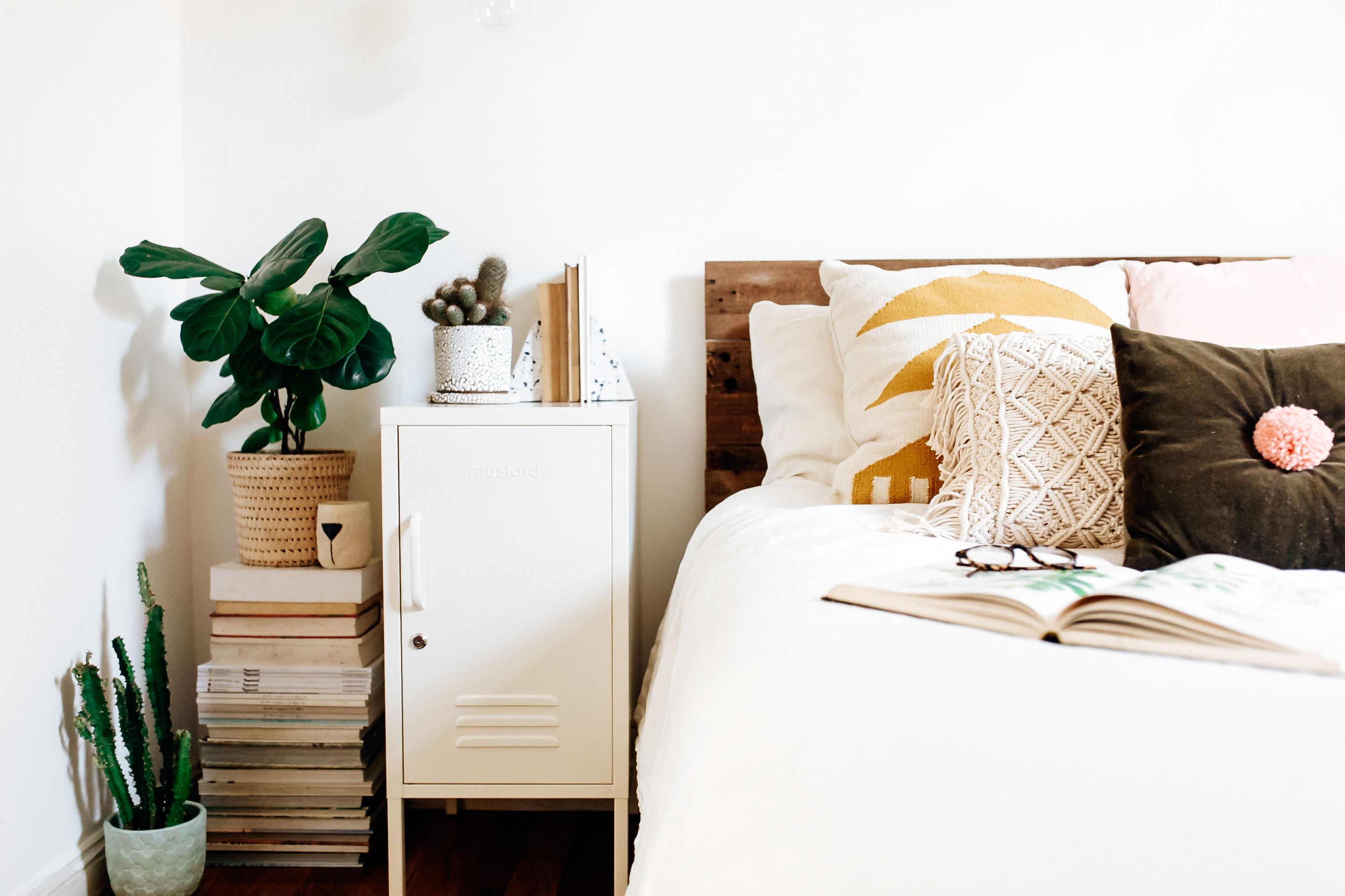 White bedroom with throw cushions and houseplants