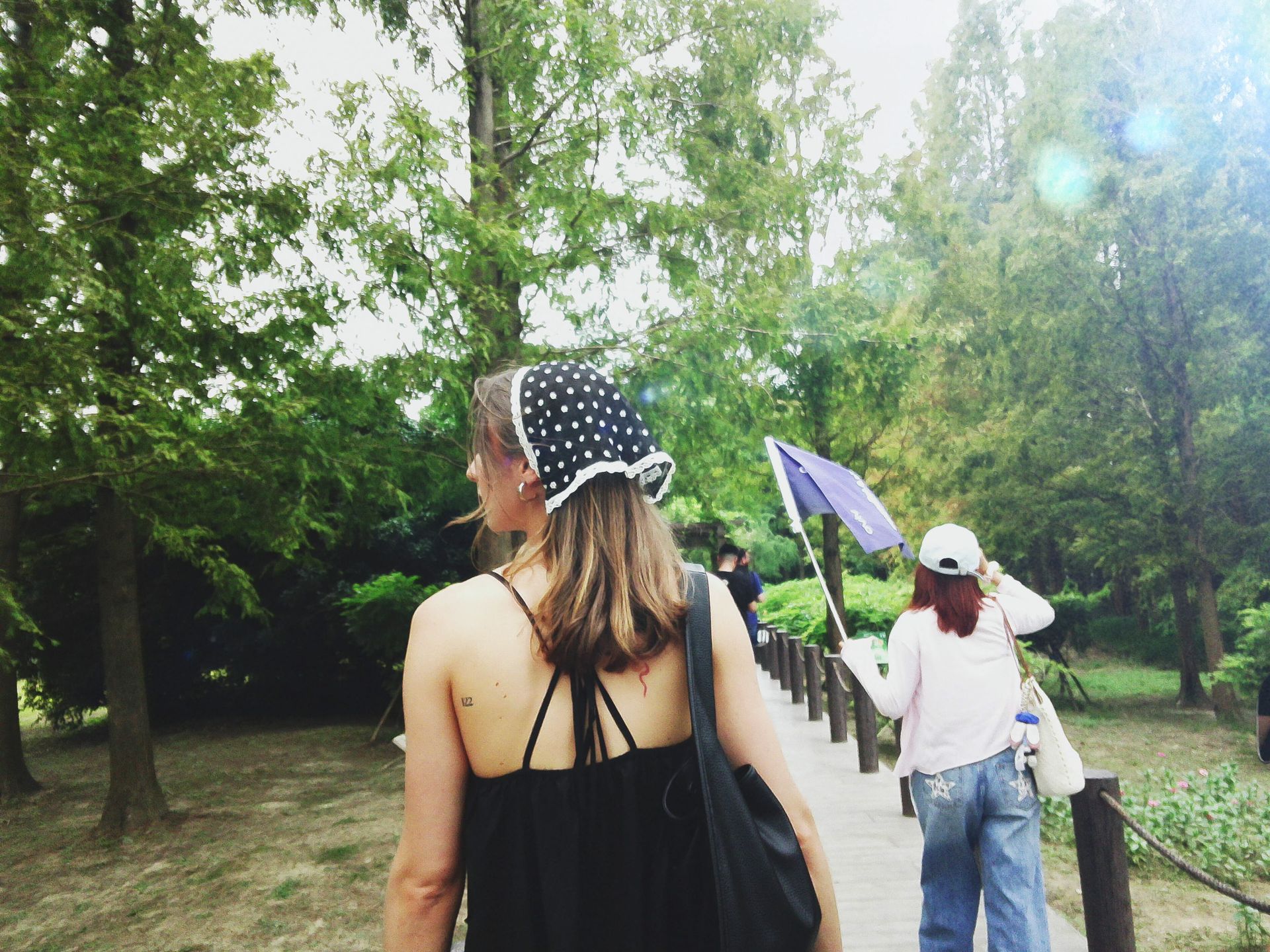 Fujifilm Instax Pal 2 sample gallery: lady walking along a wooden walkway in a forest