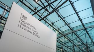 A governmental sign for the Department of Business, Energy & Industrial Strategy with glass ceiling in background