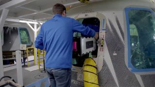 A Blue Origin employee loads the Club for the Future postcards into the company's New Shepard capsule, the RSS H.G. Wells, for their launch to space on Dec. 11, 2019.