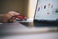 Pay day sales: Online shopper using a computer and credit card to buy products online