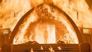 Emilia Clarke emerges from a burning building in a scene from 'Game of Thrones'.