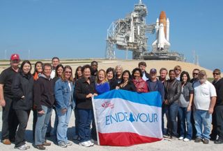 a group standing in front of the space shuttle