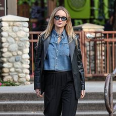 Jennifer Lawerence wearing a denim shirt with a leather blazer and trousers