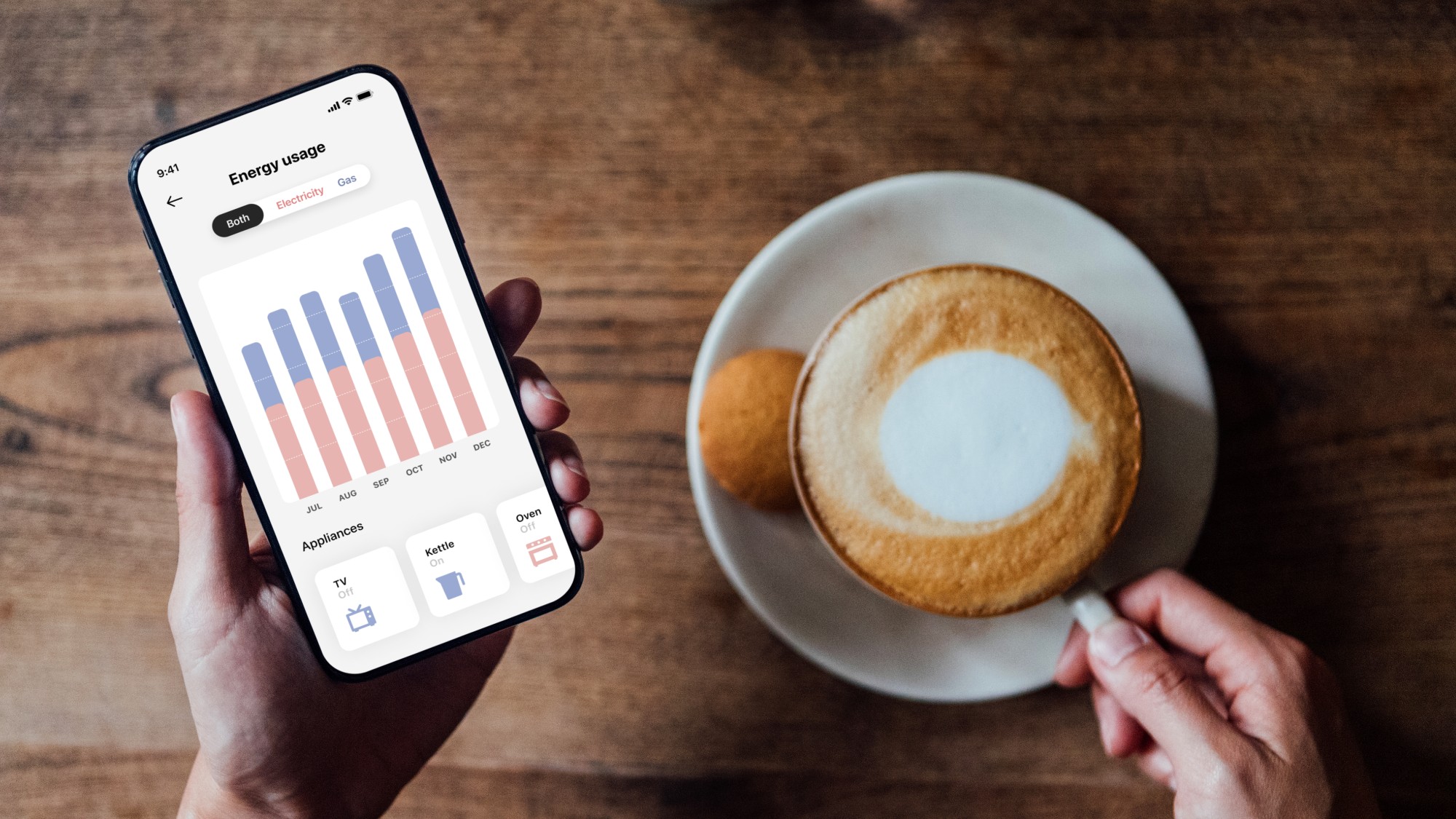 a phone showing energy usage beside a coffee cup