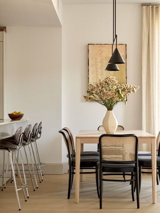 neutral walls in dining room with oak dining table and cane chairs