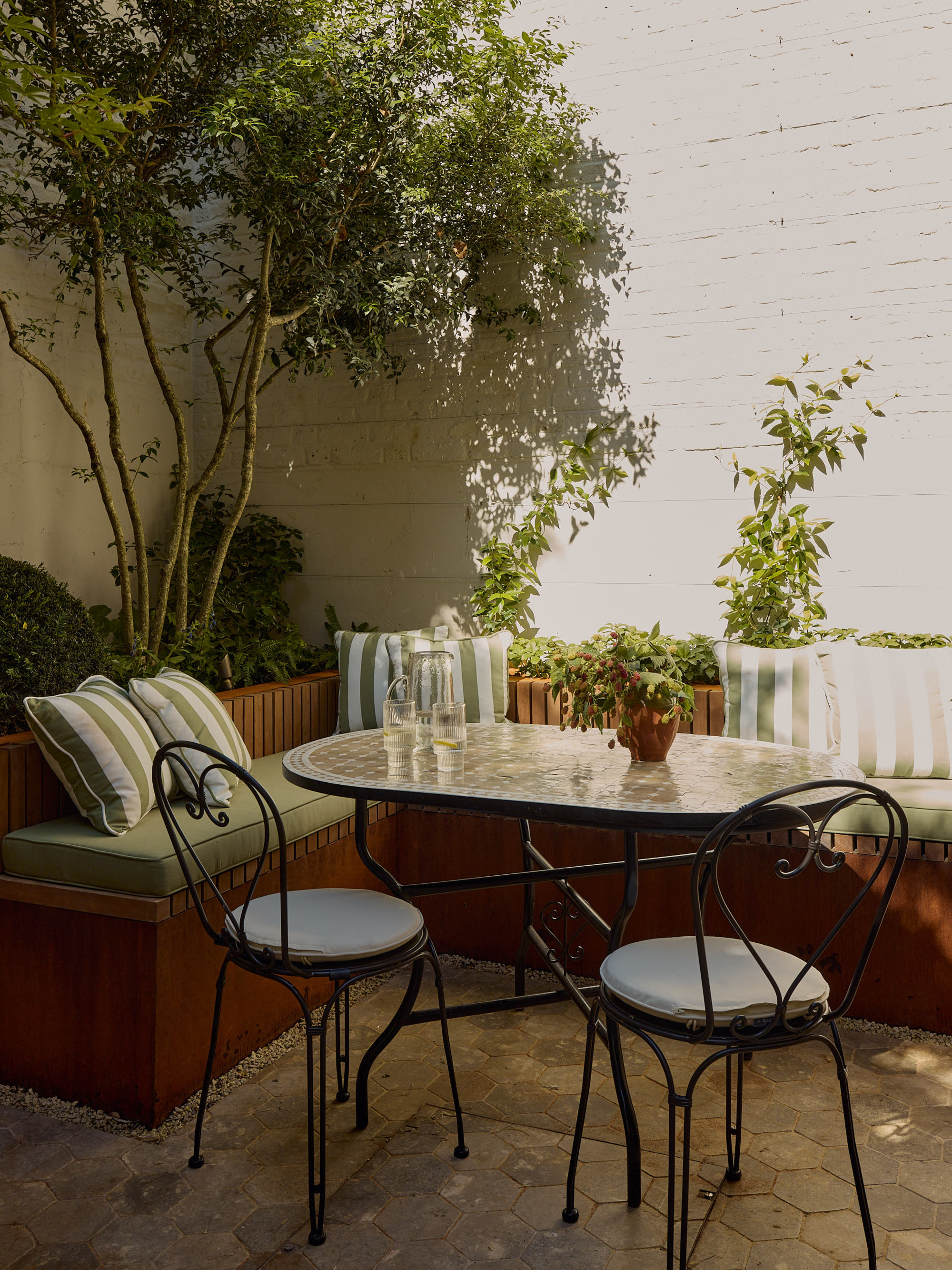 an outdoor dining area with a banquette and bistro seating