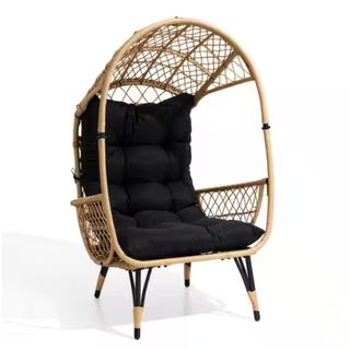 A wicker egg chair with a roof and a black cushion