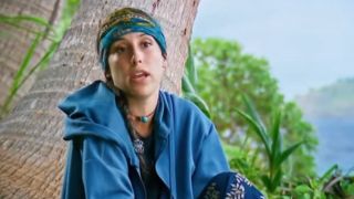Sophi wears a blue hoodie and gives a confessional during Survivor.