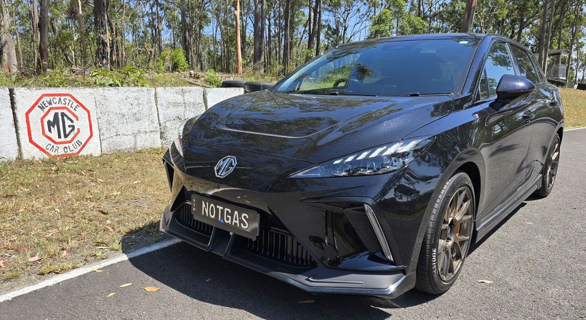 The MG4 XPOWER parked on a road with a concrete barrier behind it