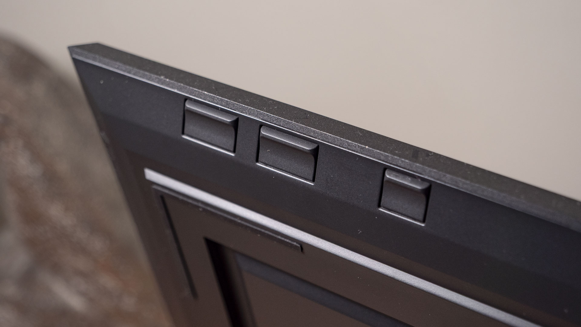 A close up of the The Aura Ink 'E Ink' digital photo frame's three control buttons