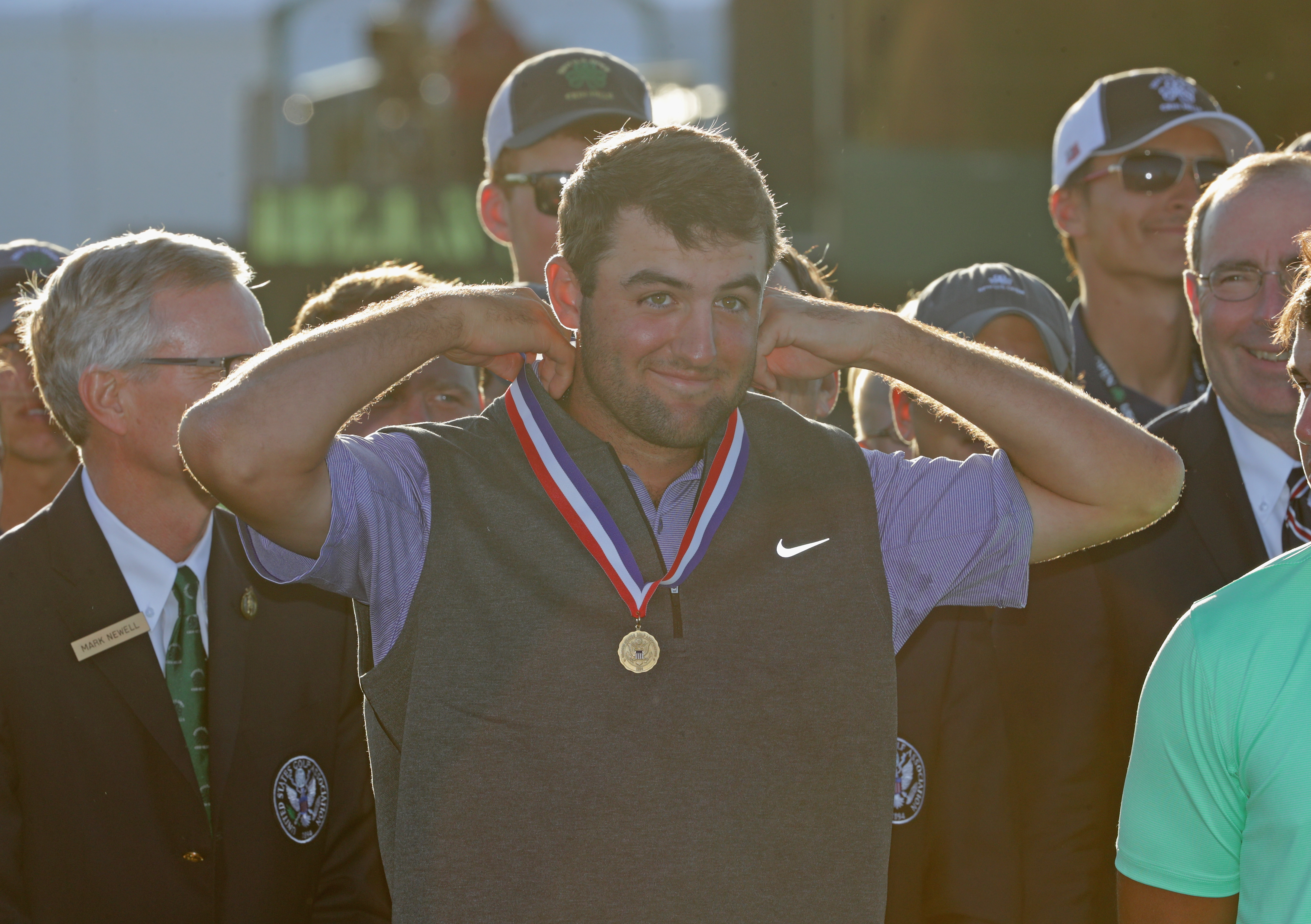 Scottie Scheffler puts a medal on