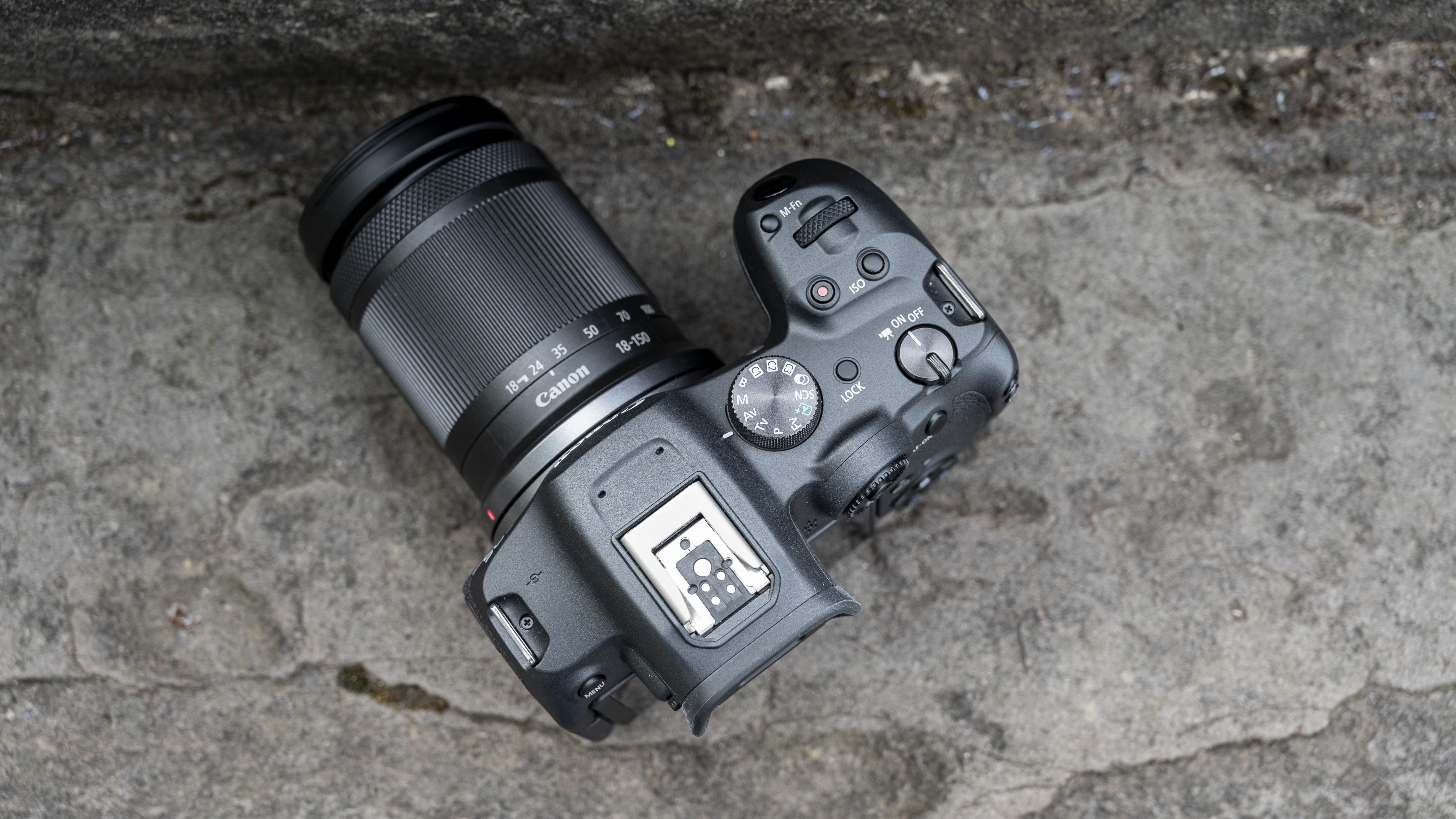 The Canon EOS R7 camera sitting on a stone step