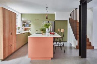 Midcentury inspired kitchen with peach kitchen island and curving stairwell