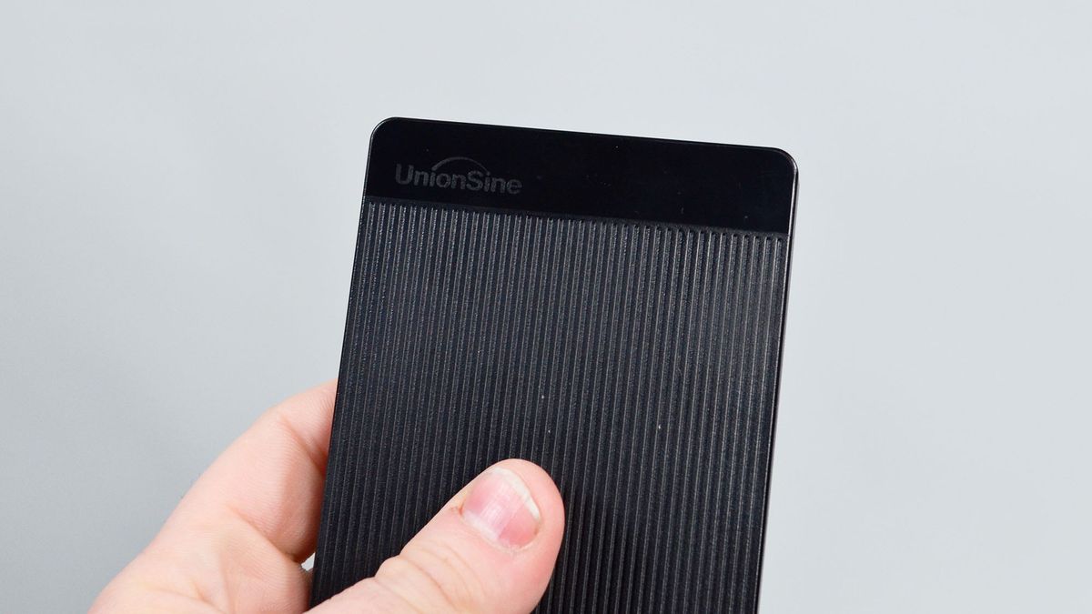A masculine hand holding a UnionSine Ultra Slim external HDD