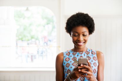 Woman looking at a smartphone and smiling