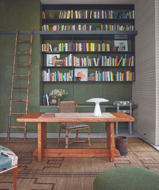 home office painted green with bookshelves