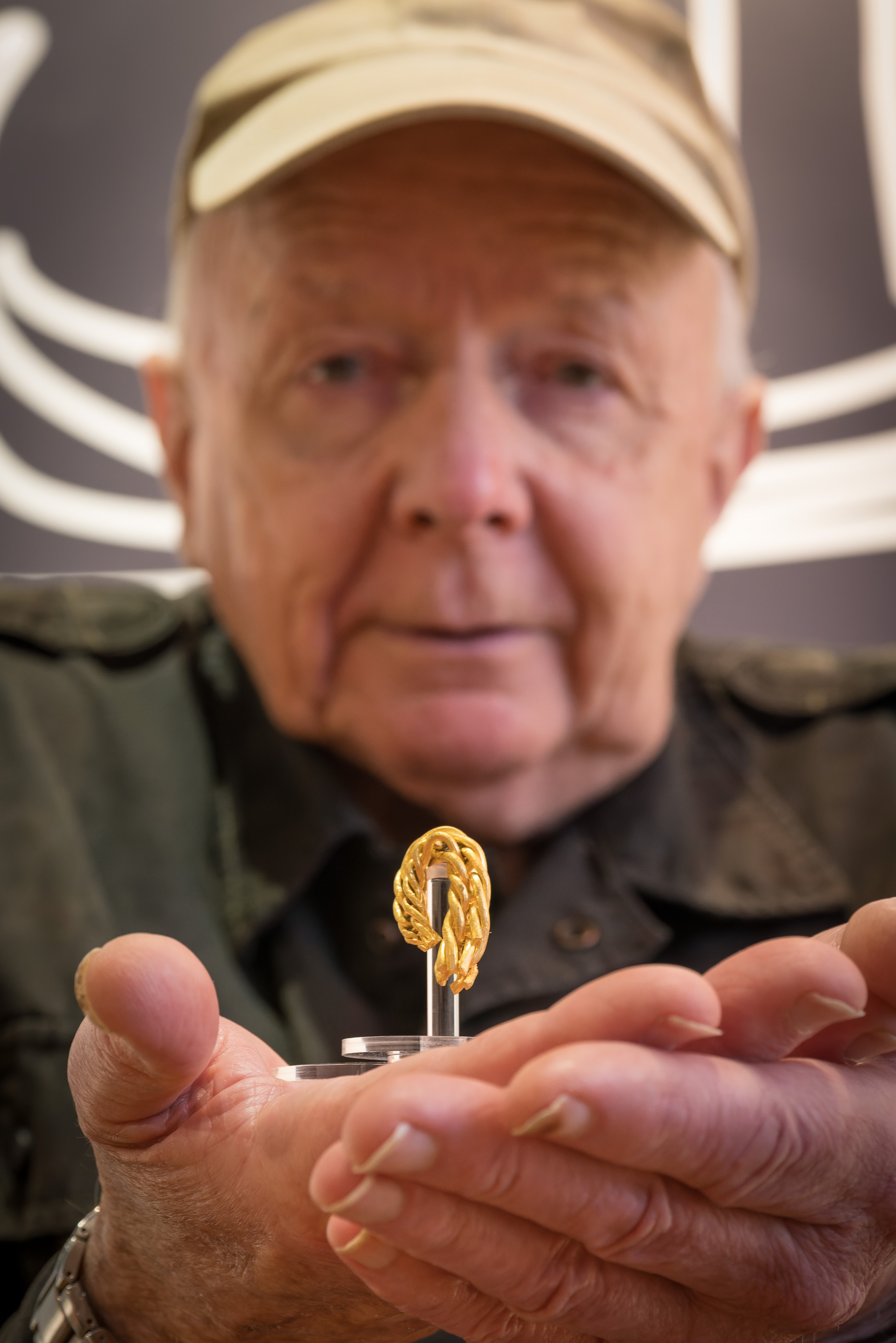 A man golds a gold arm-ring in his hands.