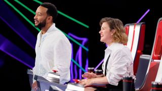 John Legend and Kelly Clarkson watch an artist on The Voice Season 29.