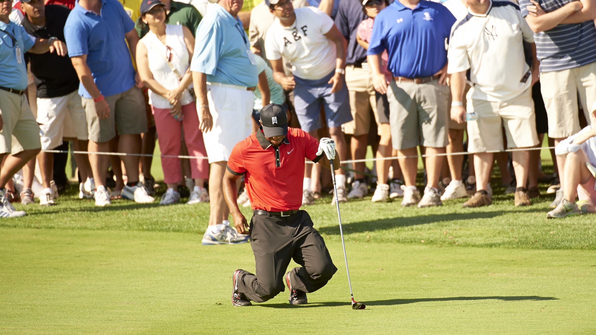 Tiger Woods on his knees in pain due to injury during the 2013 Barclays