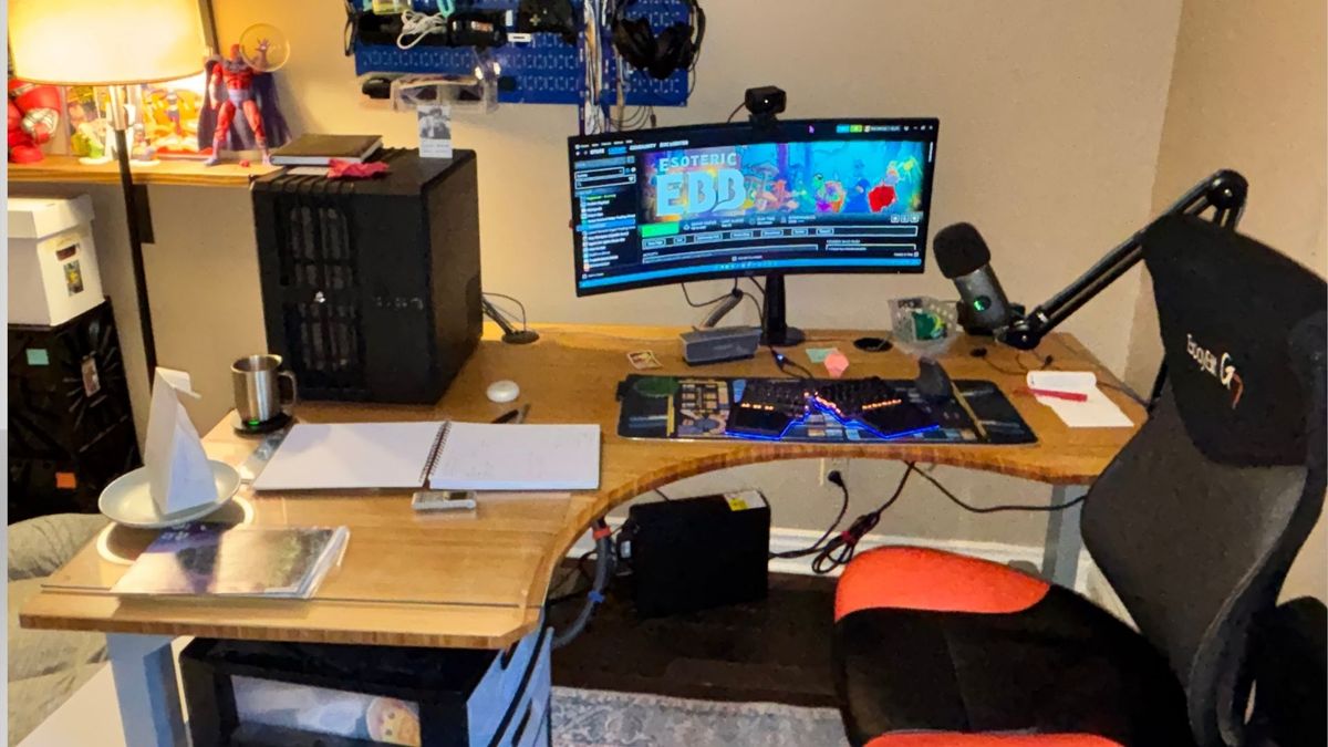 Evan Lahti's Desk, showing off a pc, ergonomic keyboard, monitor, microphone, and figurines