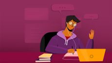 Male employee sitting at a desk working on a laptop with earphones in and books scattered on desk.