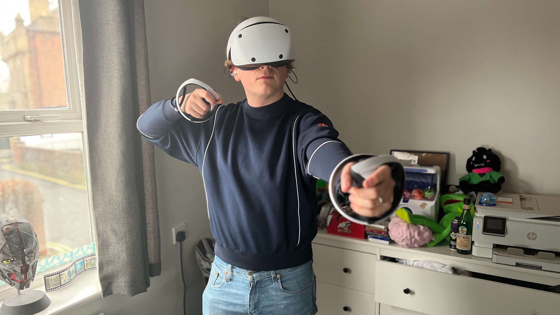 PSVR2- Man using virtual reality headset and controllers.