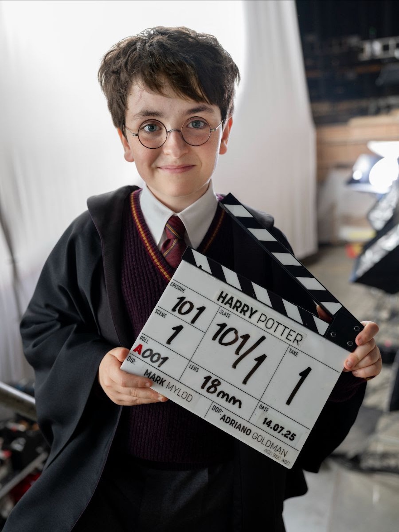 Dominic McLaughlin posing in costume as Harry Potter with a slate