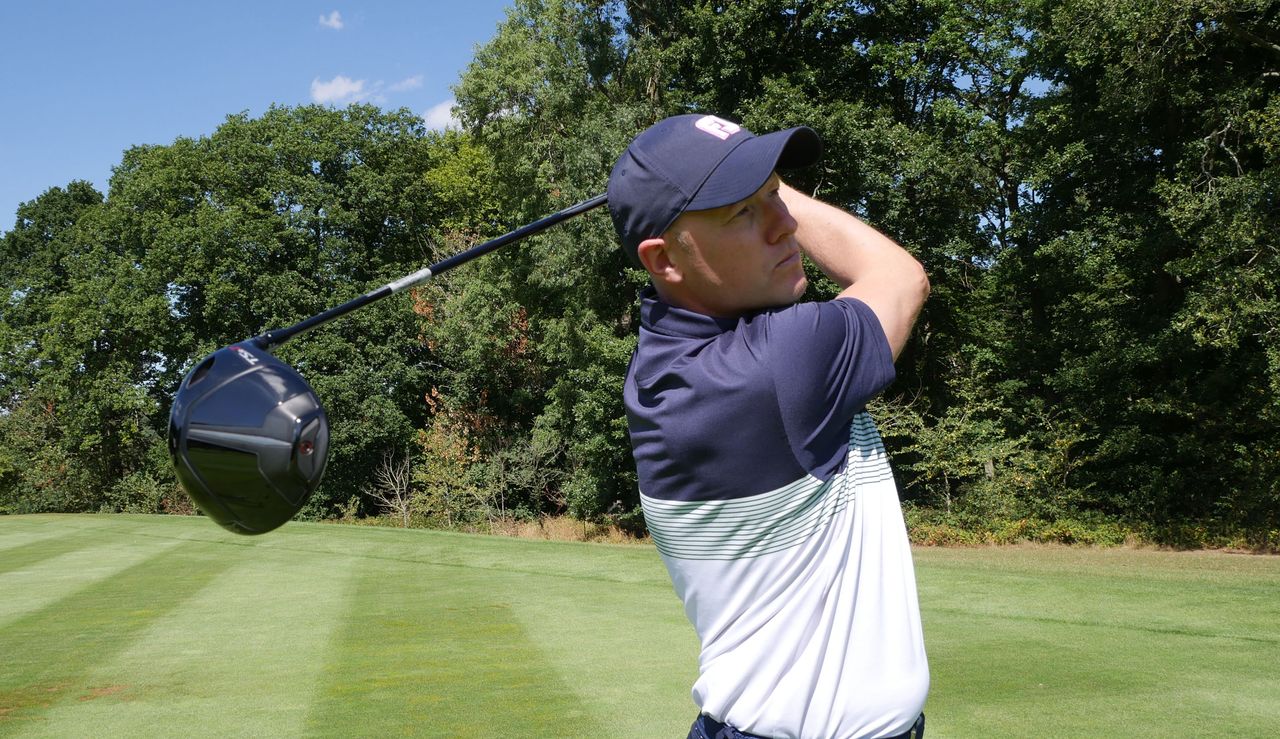 Golfer swings a driver on the range