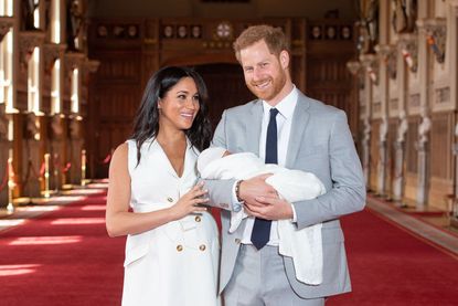 Prince Harry, Duke of Sussex and Meghan, Duchess of Sussex, pose with their newborn son Archie Harrison Mountbatten-Windsor during a photocall in St George's Hall at Windsor Castle on May 8, 