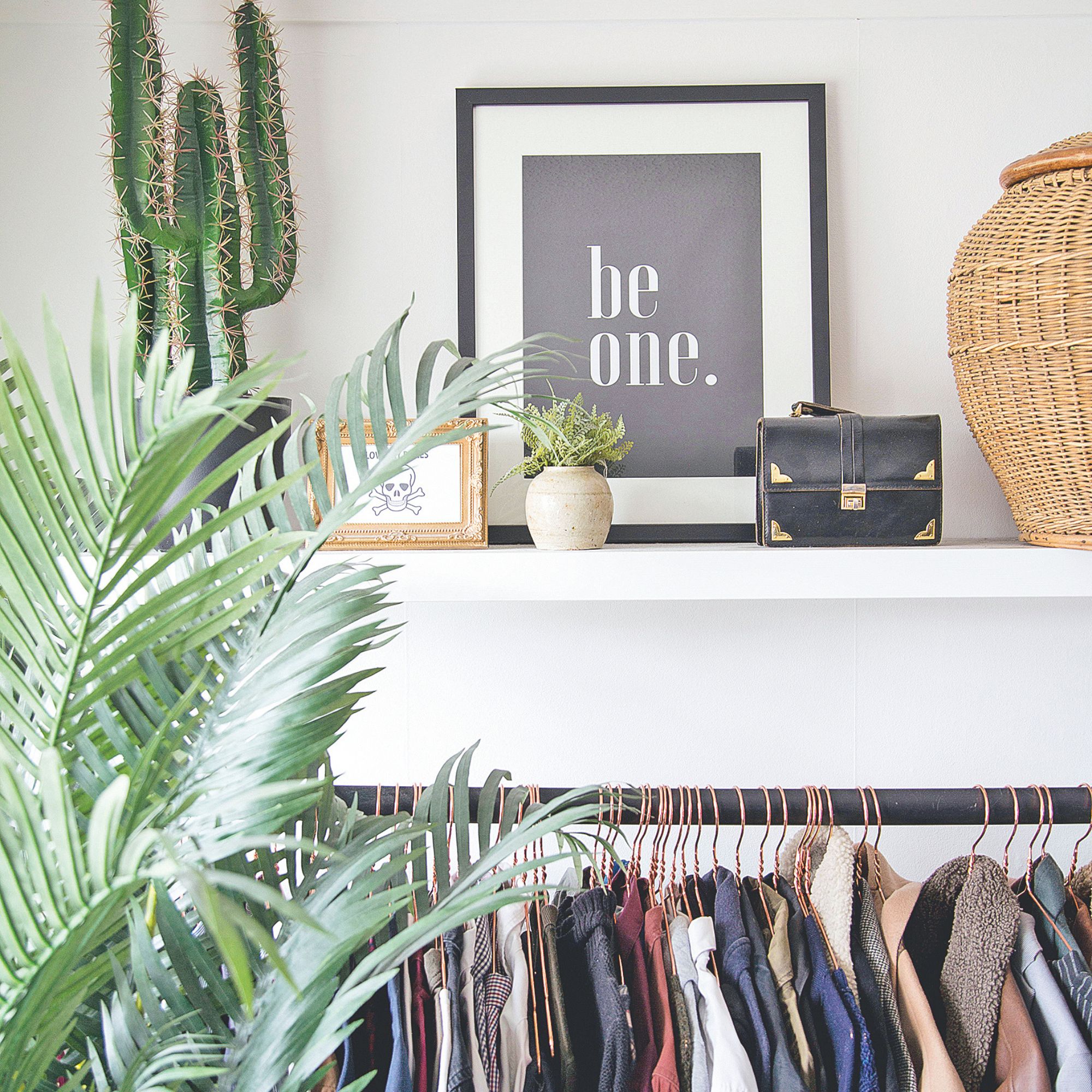 Clothes rail filled with clothes, and a shelf of smaller decor items above it