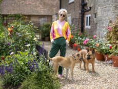 Woman in colourful tie-dye jumper and two dogs