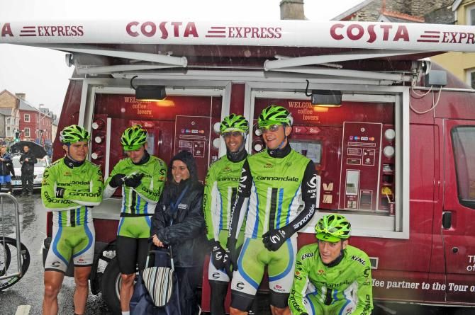 Cannondale riders shelter from the rain at the start of stage 5