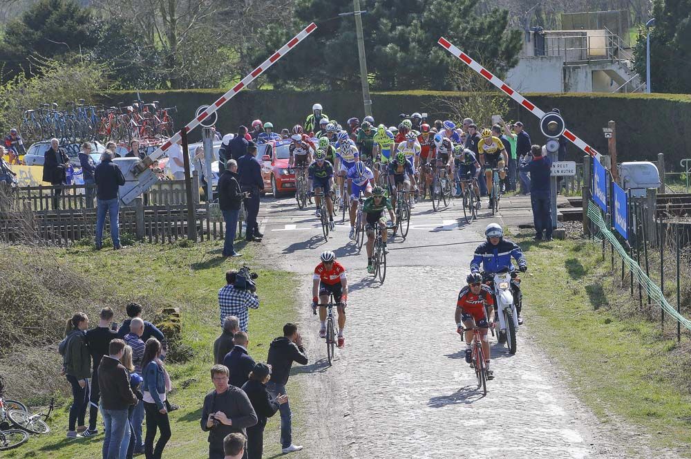 The remains of the peloton set off after the train had passed