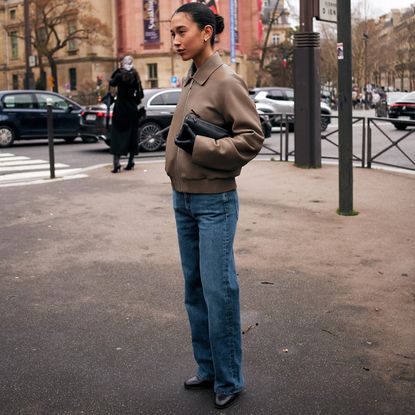 Paris fashion week fall winter 2025 attendee wearing brown leather jacket and jeans 