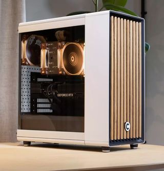 A white Chillblast Hej tower PC with a glass side panel standing on a wooden table